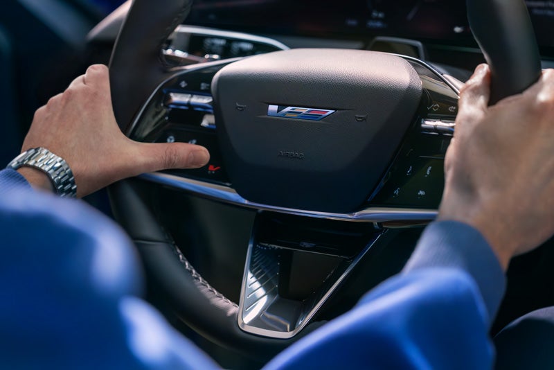 Close-up of a Man About to Press the V-Button on the 2026 OPTIQ-V Steering Wheel | Clay Cooley Cadillac in Mesquite TX